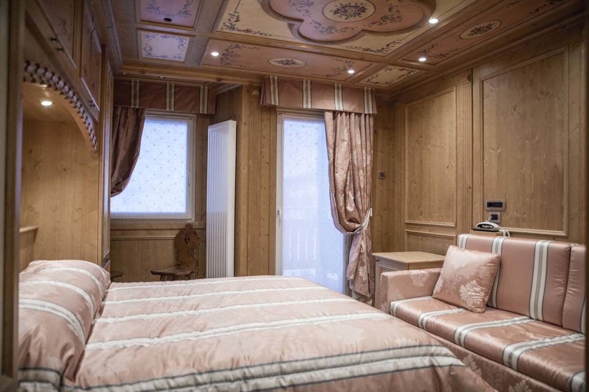 A room with a large bed, a sofa, and a small table.