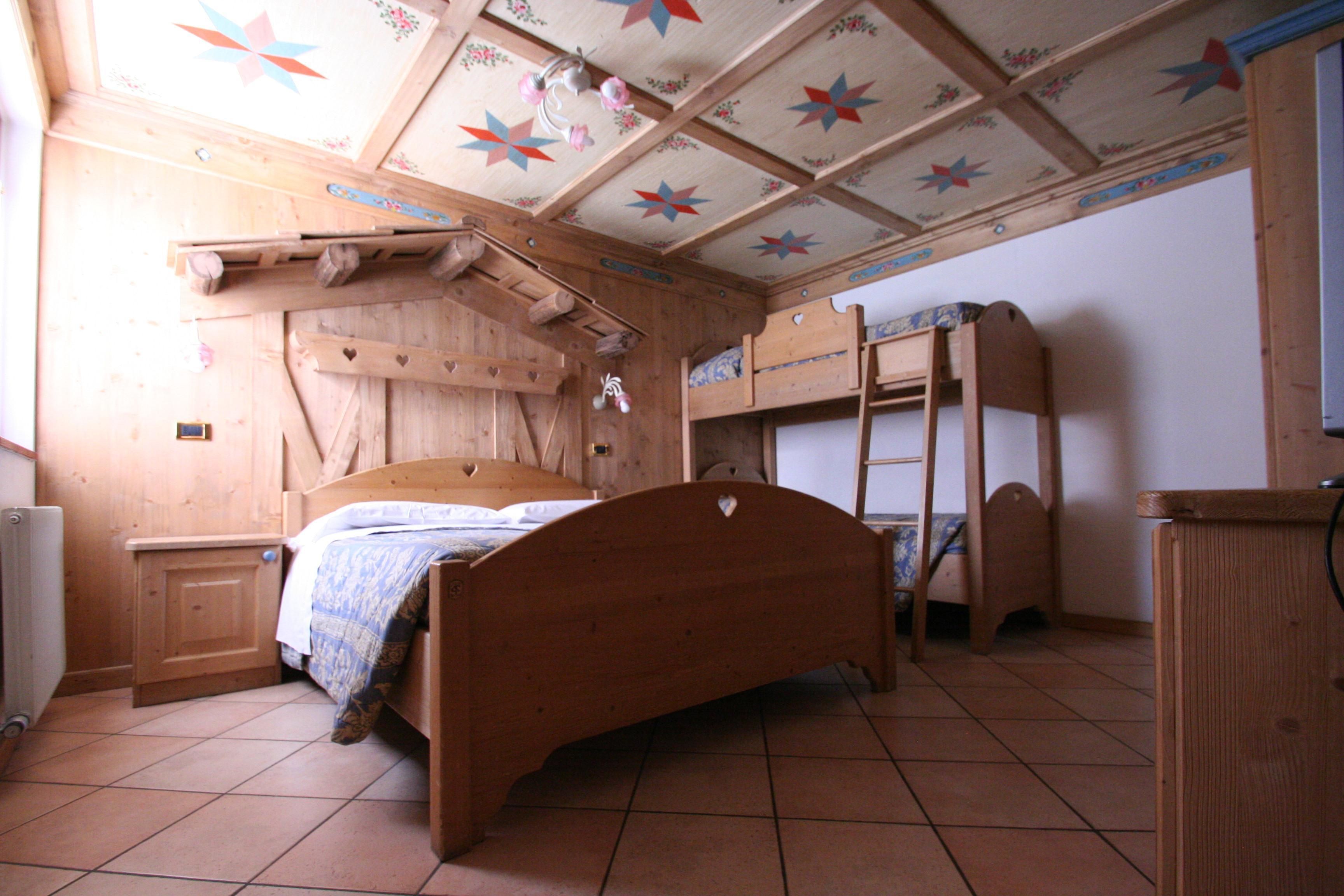 Um quarto de madeira com uma cama de solteiro, uma cama simples e um guarda-roupa de madeira.
