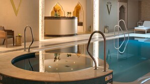 Una piscina con hidromasaje, una recepción y un área de descanso.