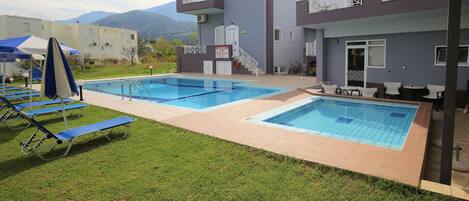 Een seizoensgebonden buitenzwembad en parasols bij het zwembad