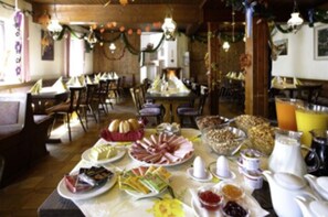 A dining area with tables set for breakfast, including plates of food, bread, and beverages. - Gasthaus Mooshäusl (Hebertshausen)
