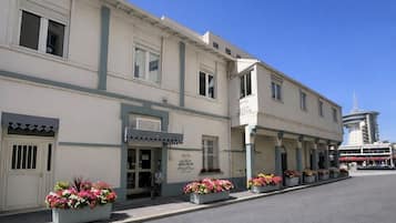 Un hôtel à la façade classique, doté de nombreuses fenêtres et d’une enseigne indiquant qu’il s’agit de « l’hôtel Le Petit Boigneur ».
