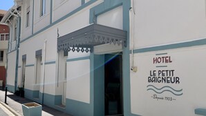 Un edificio con un letrero que dice "HOTEL LE PETIT Baigneur" y la fecha "Depuis 1903".