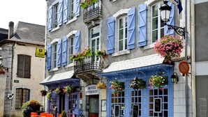 Un hotel con un cartello che recita 'Hotel de France' e posti a sedere all'aperto con tavoli e sedie.