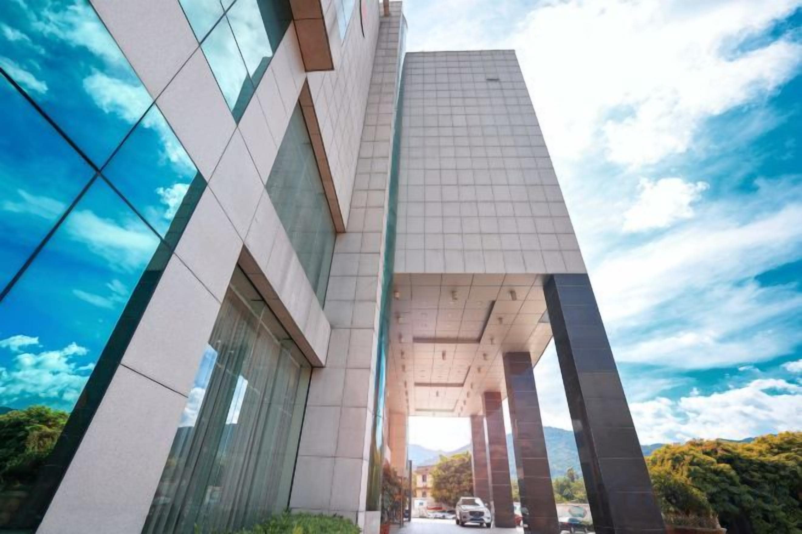 A modern building with a glass facade and a clear sky.