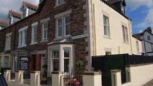 A two-story building with a stone facade and a white upper section. - Salisbury Guest House (Keswick)