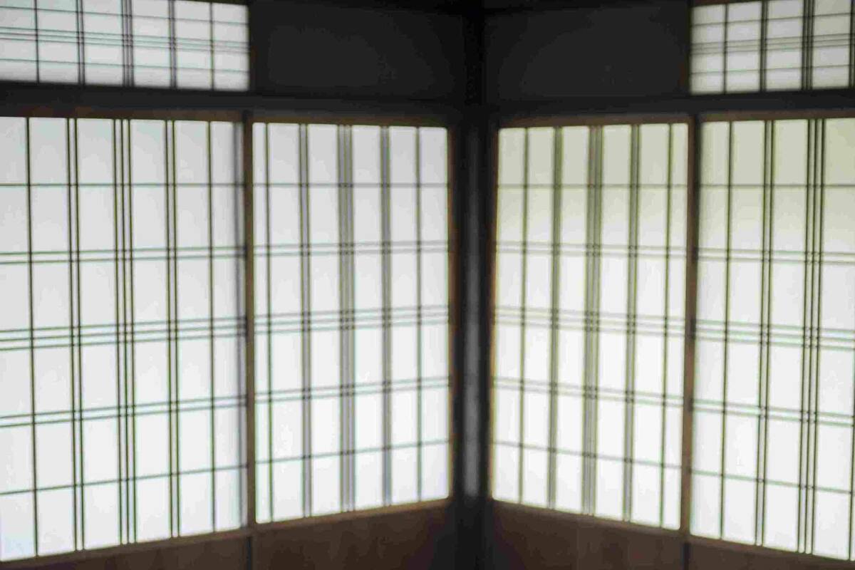 Una habitación japonesa tradicional con suelo de tatami, una mesa baja y puertas correderas shoji.