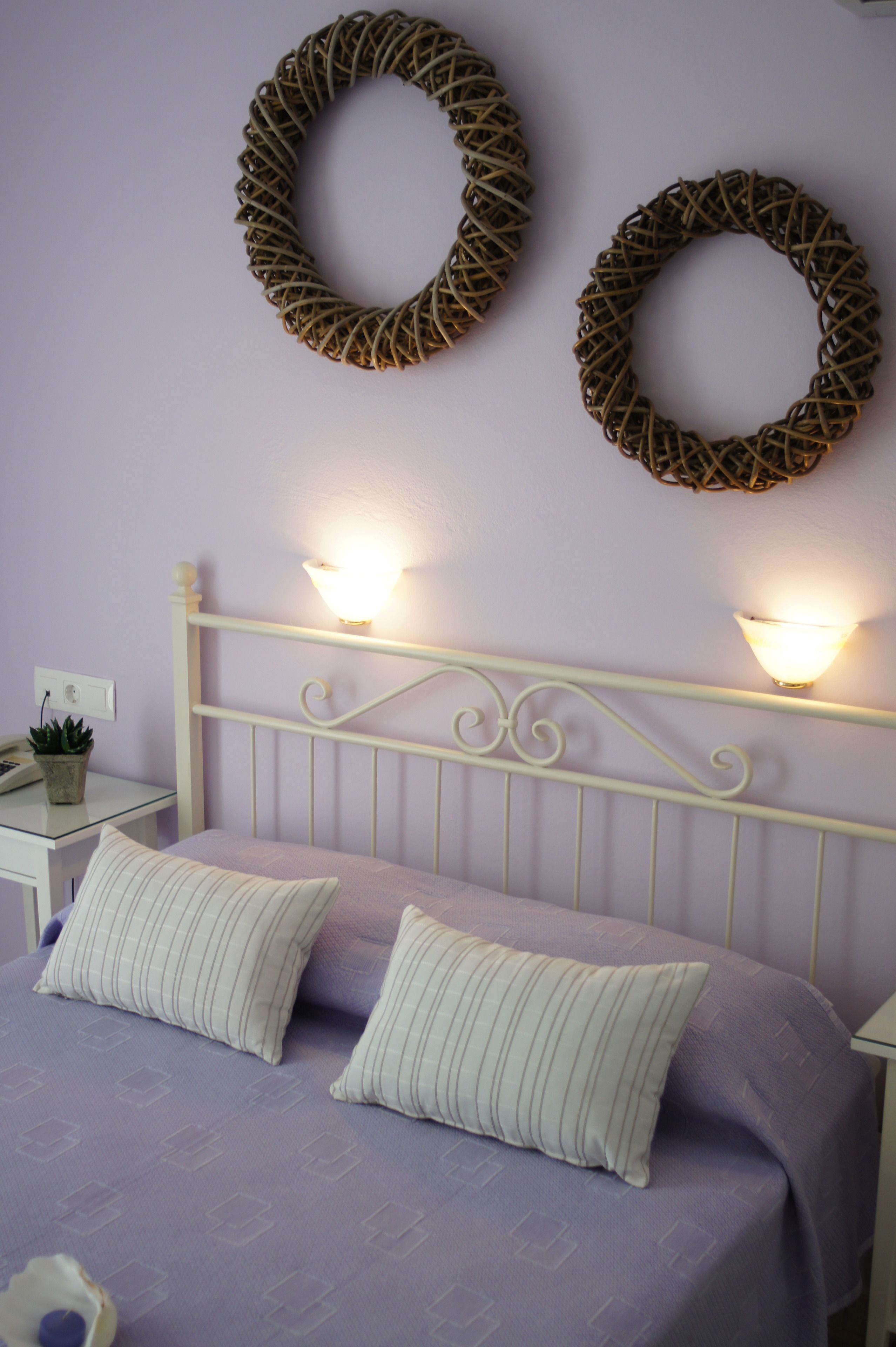 Una camera da letto con un letto, due lampade a parete e un'asse decorativa al muro.
