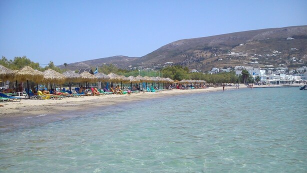 A beach with clear water, umbrellas, and beach chairs. - Cyclades Hotel (Paros)