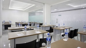 A modern conference room with tables, chairs, and water bottles. - Amaris Hotel Juanda (Jakarta)