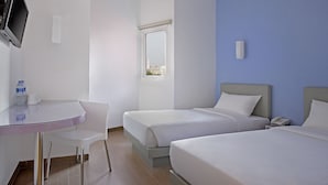 A hotel room with two beds, a desk, a chair, a TV, and a window with a city view. - Amaris Hotel Juanda (Jakarta)