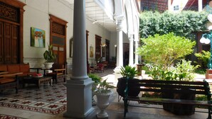 Un vestíbulo amplio con suelo de baldosas, muebles de madera y plantas en macetas.