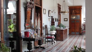 Una habitación con piso estampado, muebles de madera y un candelabro.