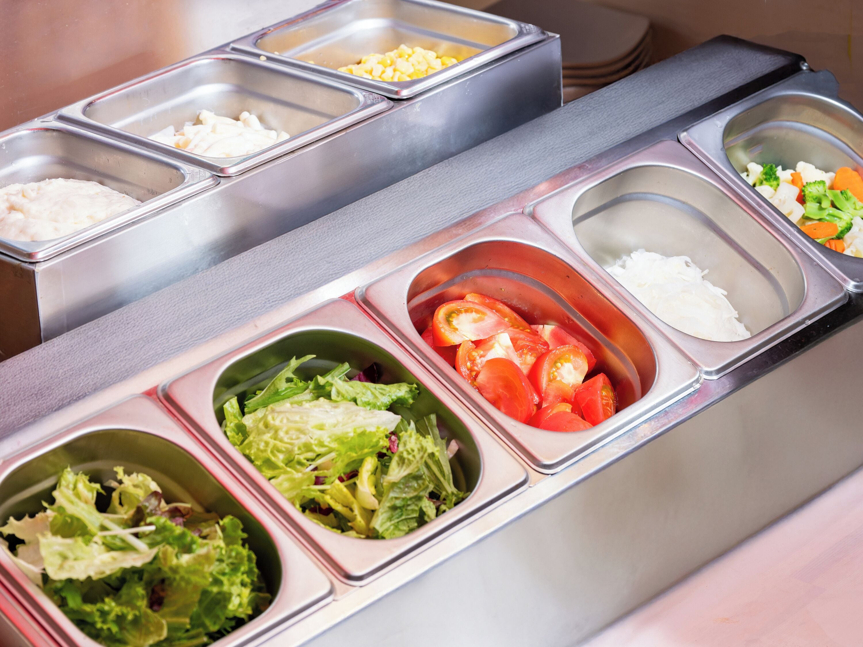 A buffet with various food options including vegetables, rice, and other dishes.
