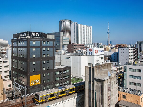 A multi-story building with a prominent 'APA' sign, surrounded by other high-rise buildings and a clear sky. - APA Hotel Akihabara Ekimae (Tokyo)