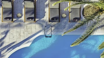 Een buitenzwembad, parasols voor strand/zwembad