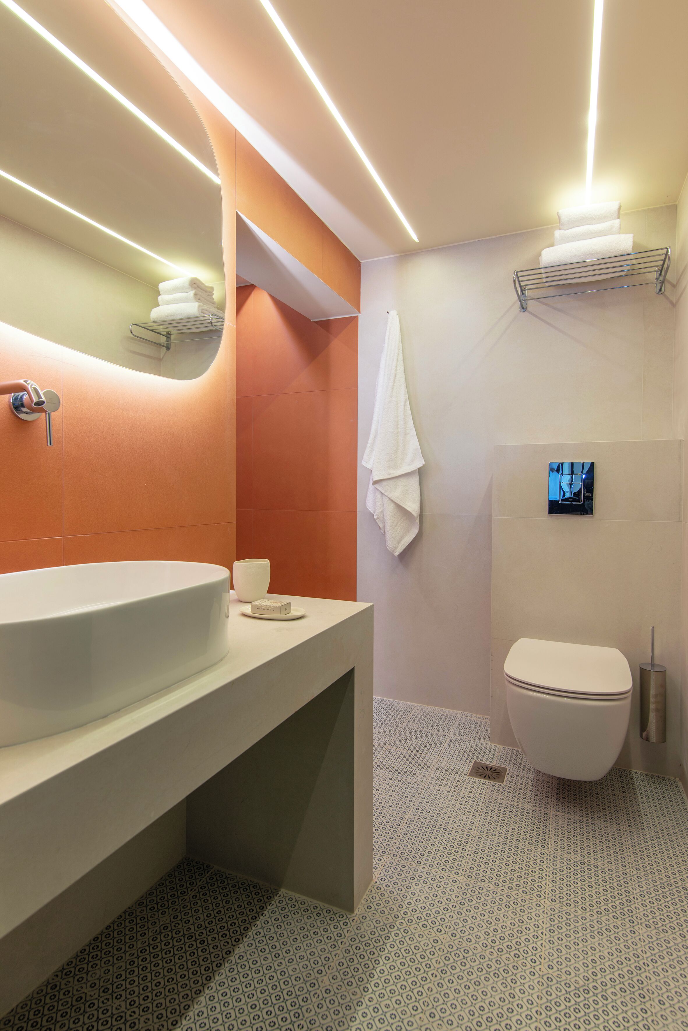 A modern bathroom with a large white sink, a toilet, and a shower area.
