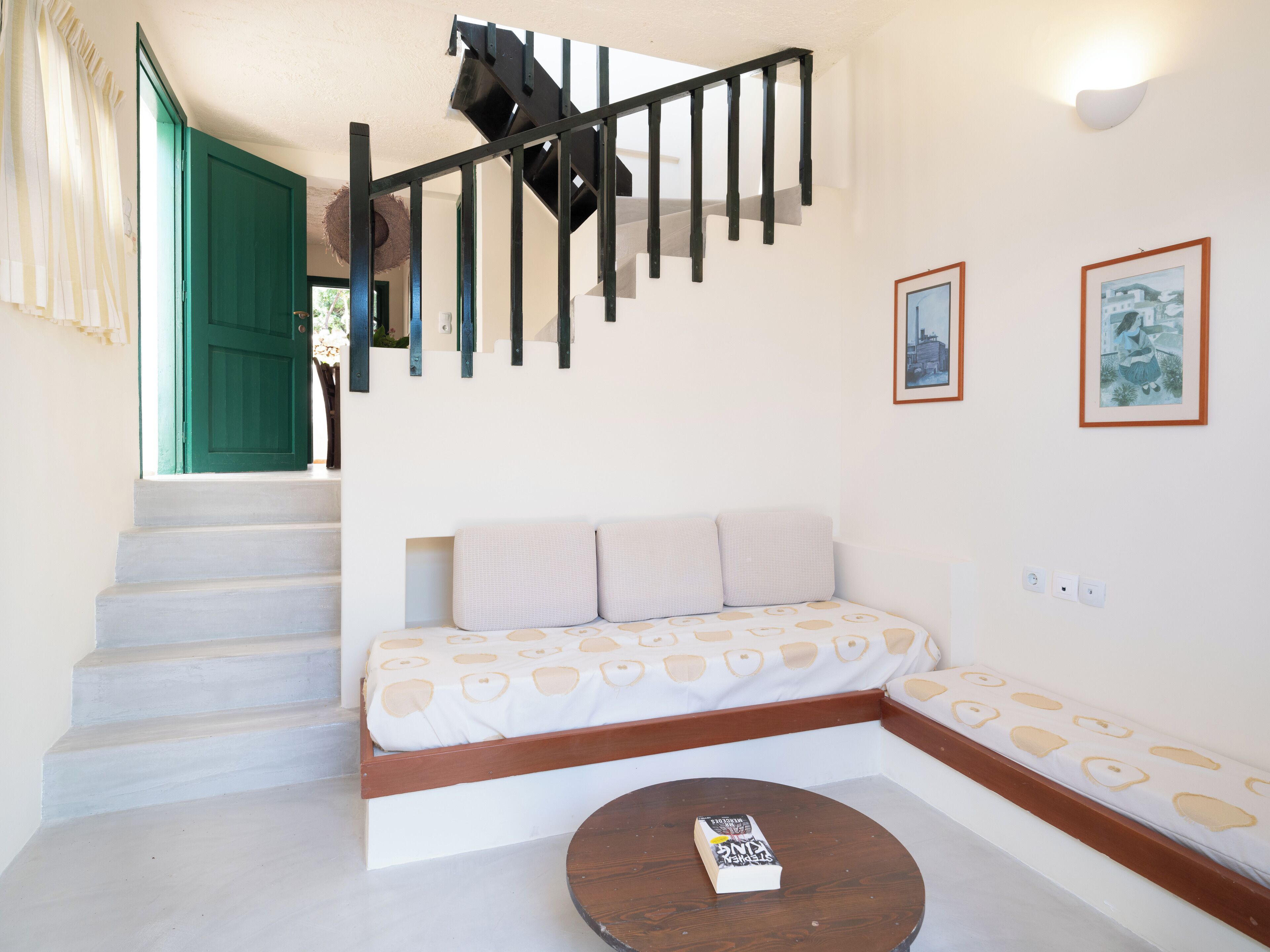 Une pièce avec un escalier, un canapé et une petite table.