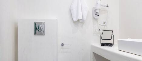 Un bany amb vàter, un lavabo, un assecador i una paperera.