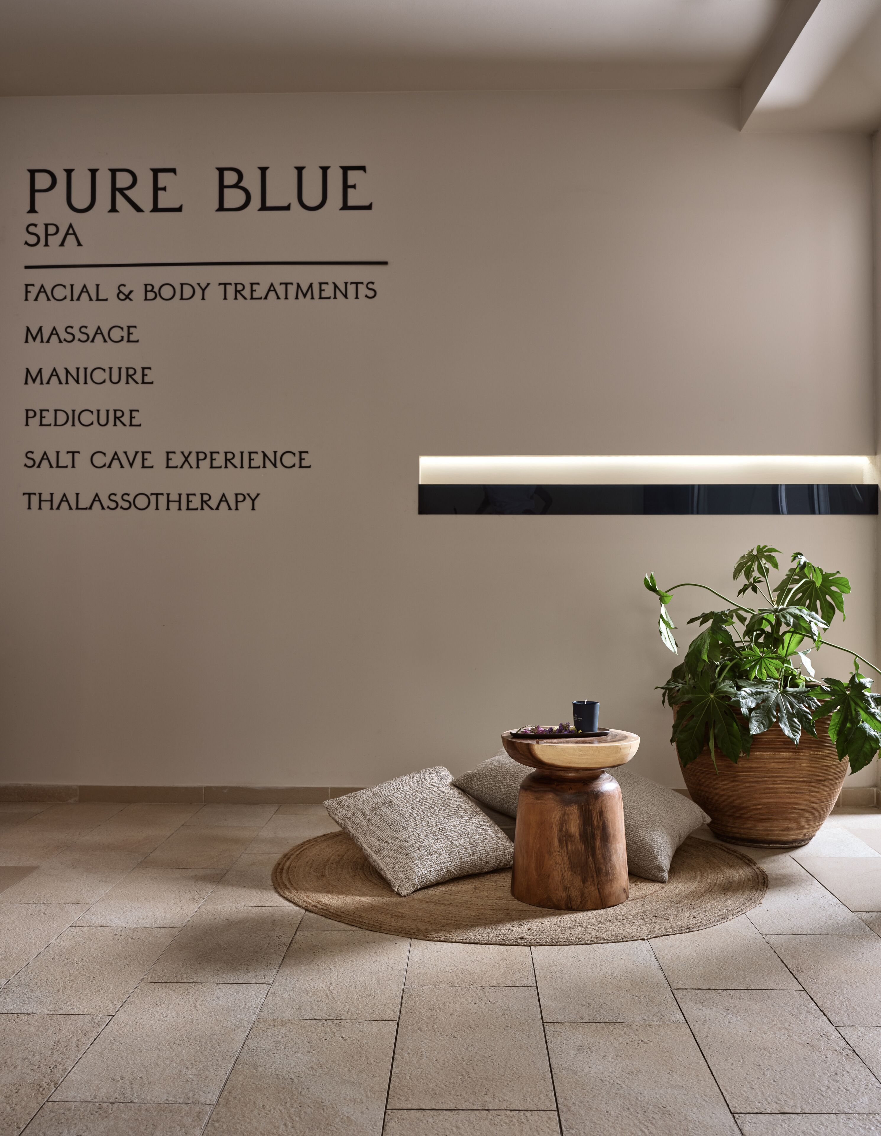 Un cuarto de spa con una lista de servicios como tratamientos faciales y corporales, masaje, manicura, pedicura, experiencia en gruta de sal y talasoterapia.