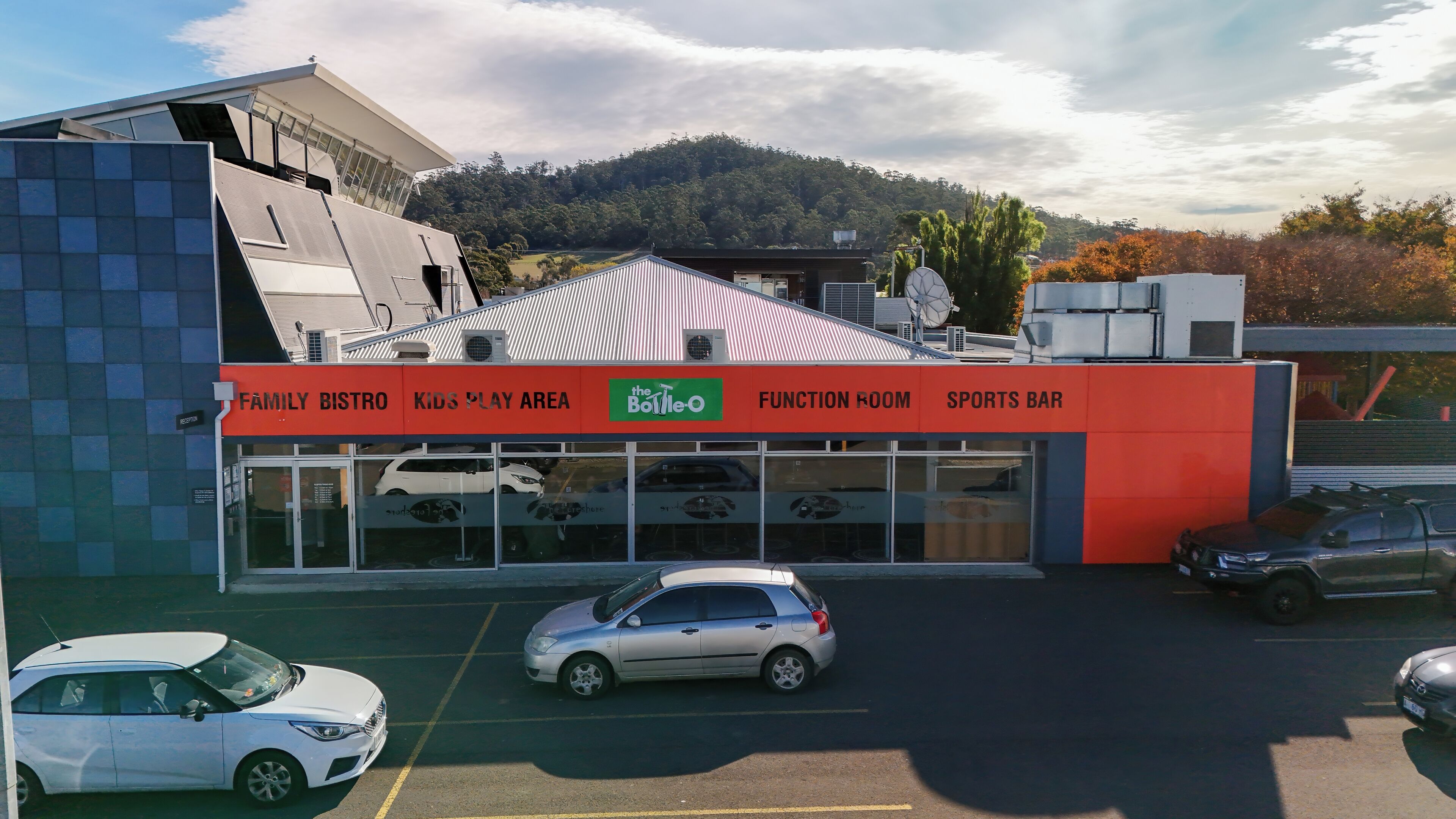 A building with a red and white facade, a kids play area, a family bistro, a function room, and a sports bar.