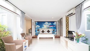A modern hotel room with a bed, a TV, a desk, and a chair.