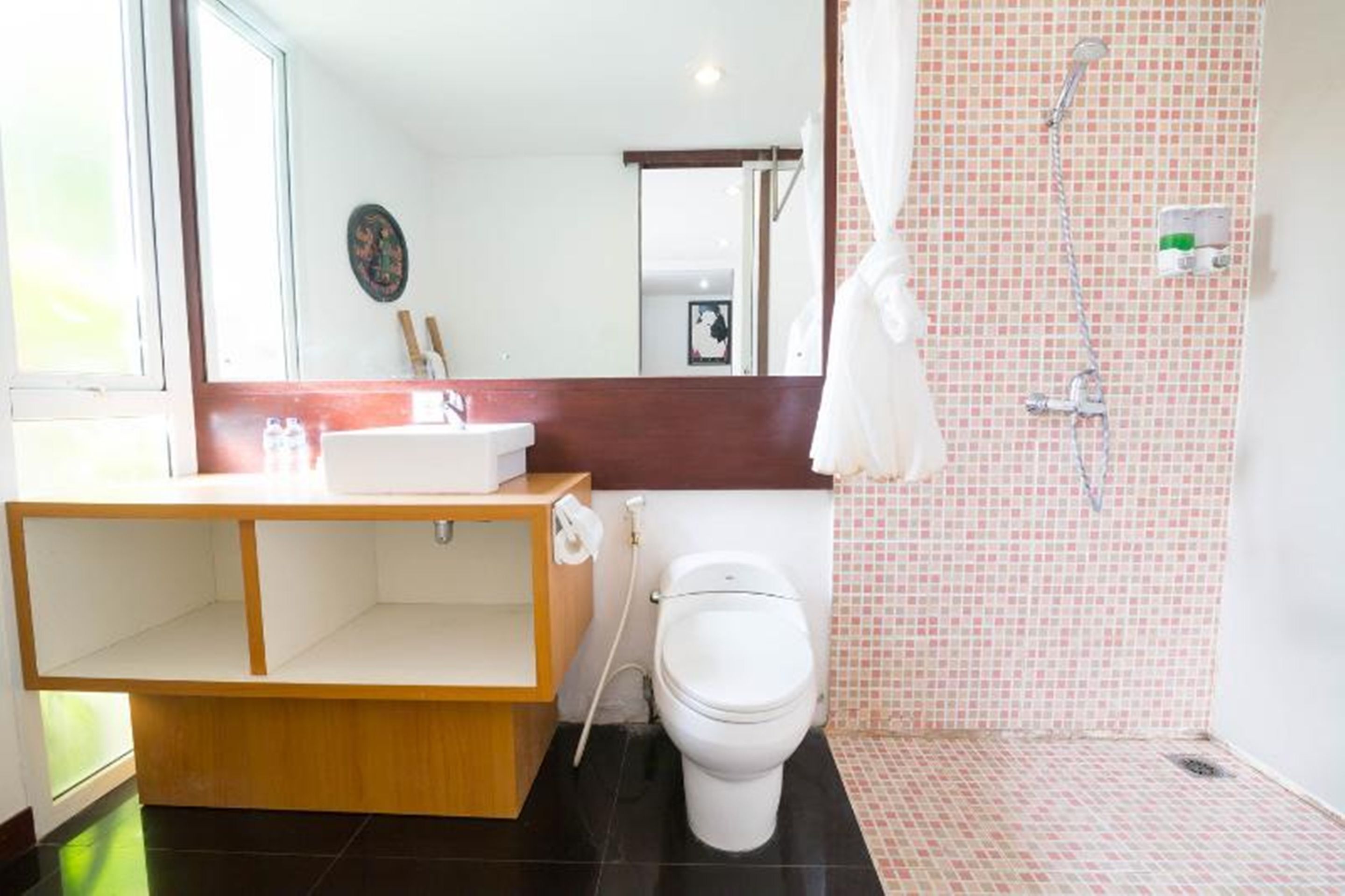 Une salle de bain avec des toilettes, un lavabo et une douche.