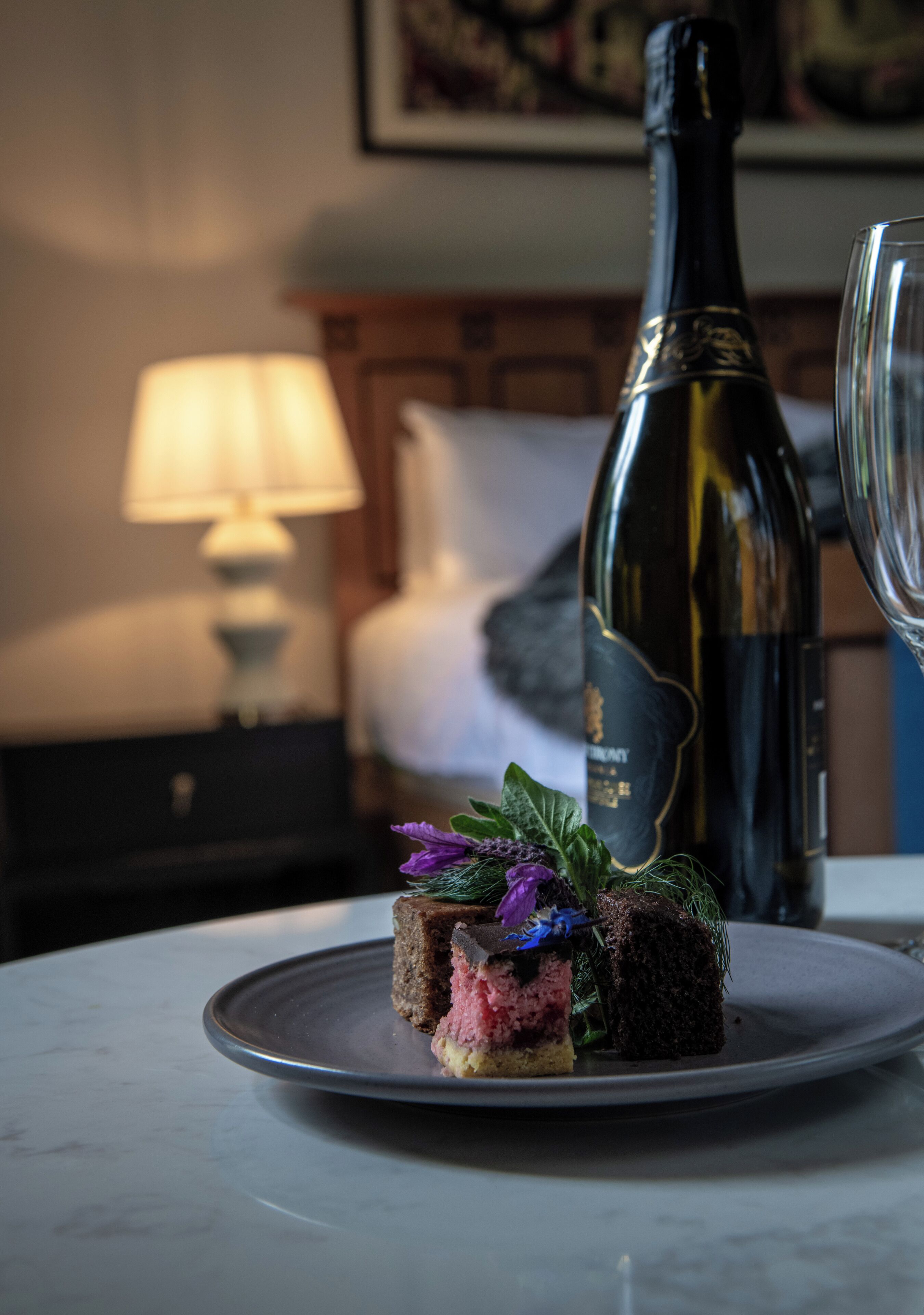 Un dessert présenté sur une assiette, avec une bouteille de vin et un verre en arrière-plan.