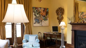 A well-lit living room with a chandelier, a sofa, a coffee table, and a fireplace.