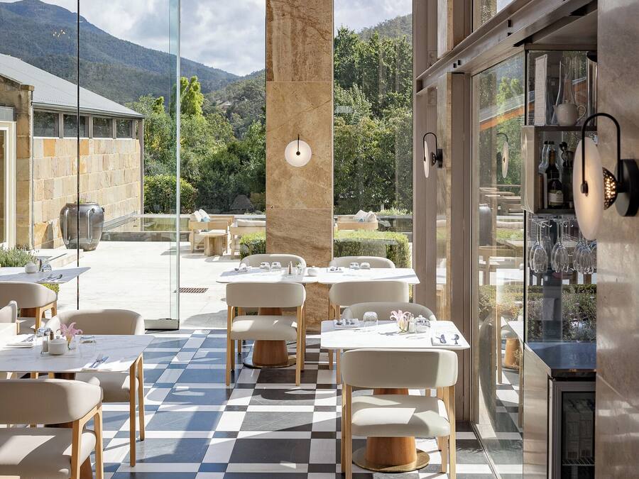 A modern outdoor dining area with checkered flooring and natural light from large windows.