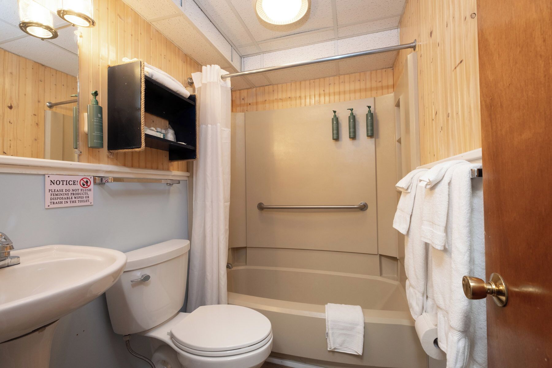 Un baño con inodoro, lavamanos, ducha y toallero.