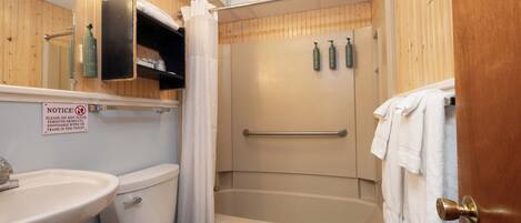 Un baño con inodoro, lavamanos, ducha y toallero.