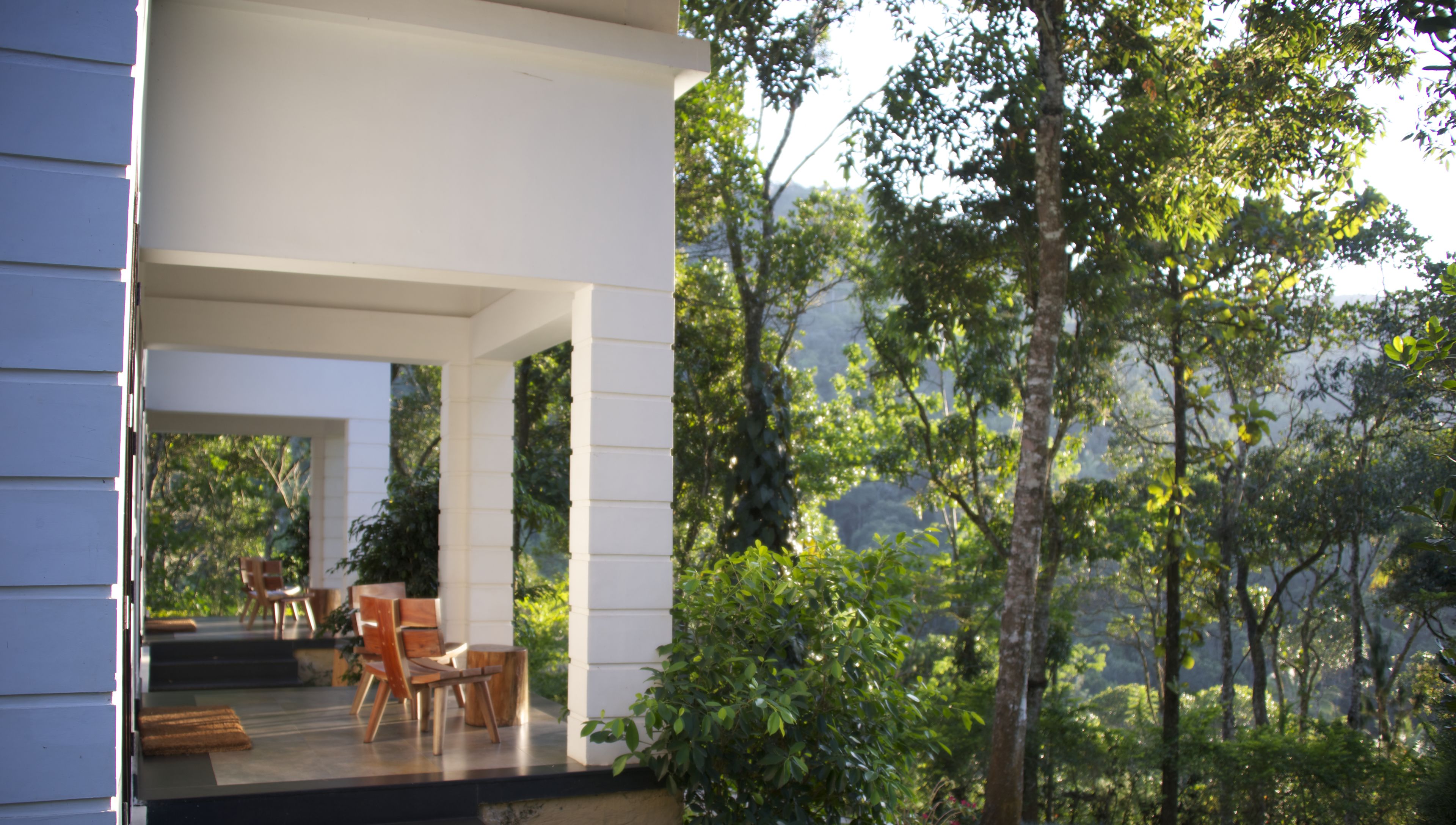 A modern outdoor seating area with a view of a forested landscape.