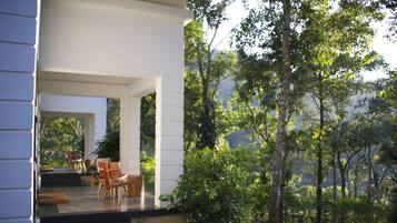 A modern outdoor seating area with a view of a forested landscape.