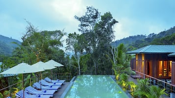 Una piscina al aire libre, sillones reclinables de piscina