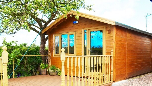 A wooden cabin with a wooden deck and a small porch. - Quixhill - Denstone - Dove Meadow B & B (Uttoxeter)
