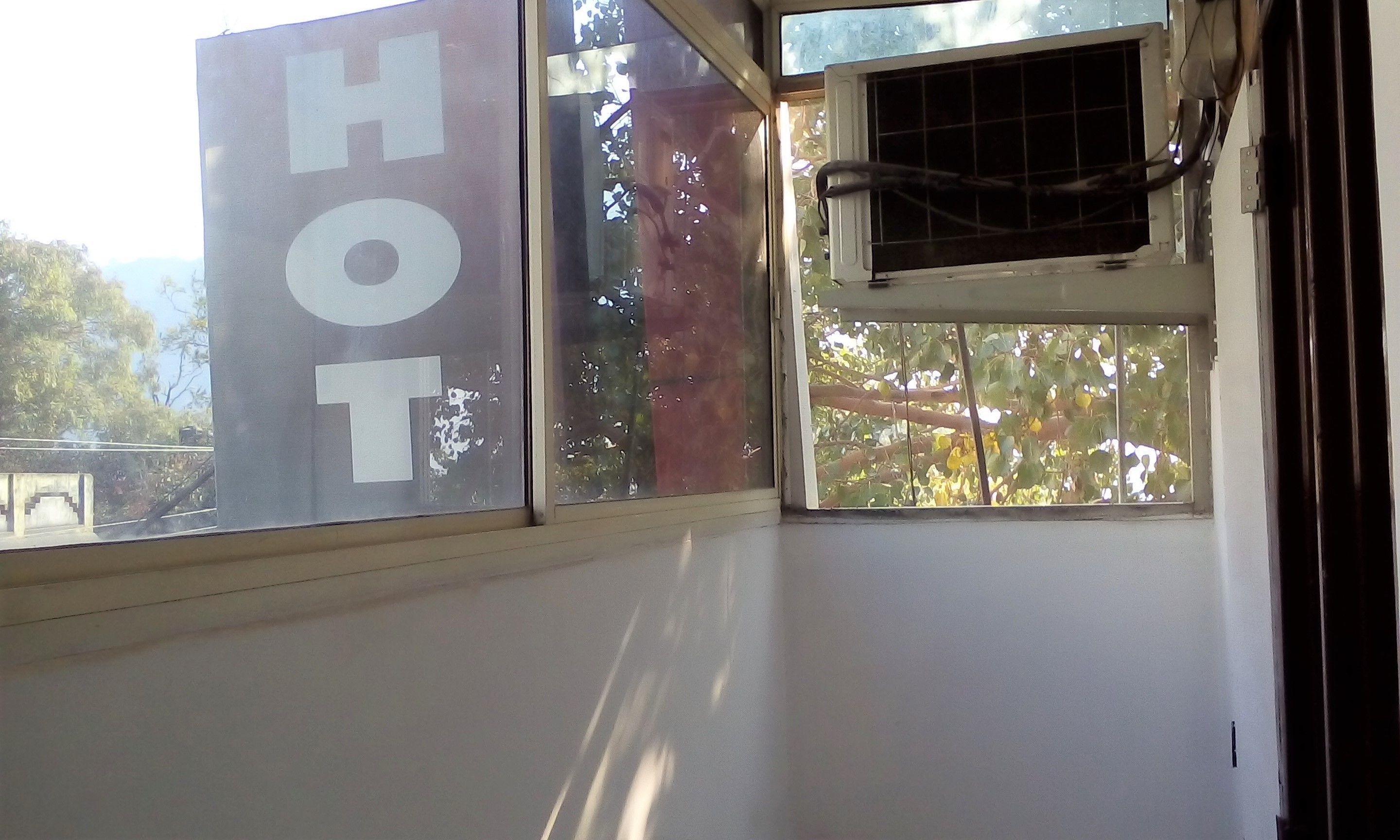 A room with a large window displaying the word "HOT" and a smaller window with a grid pattern.