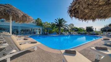 Relax by the serene pool surrounded by lounge chairs and shaded umbrellas.