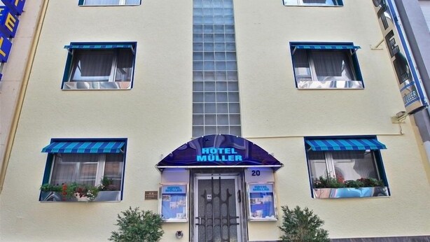 A hotel with a central entrance, multiple windows, and a number '20' sign. - Hotel Müller (Cologne)