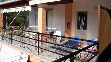 Relax on the balcony with a lounge chair and wicker chair, taking in the view.
