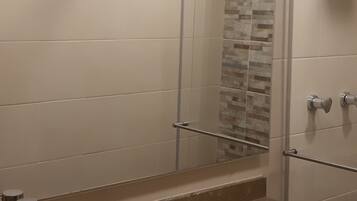 A modern bathroom with a glass shower enclosure, a sink, and a toilet.