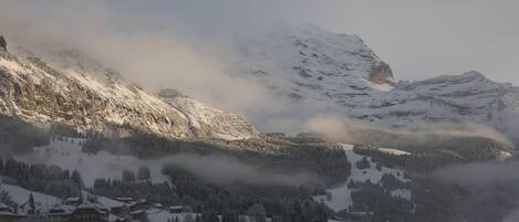 Une montagne enneigée, avec un village à ses pieds.