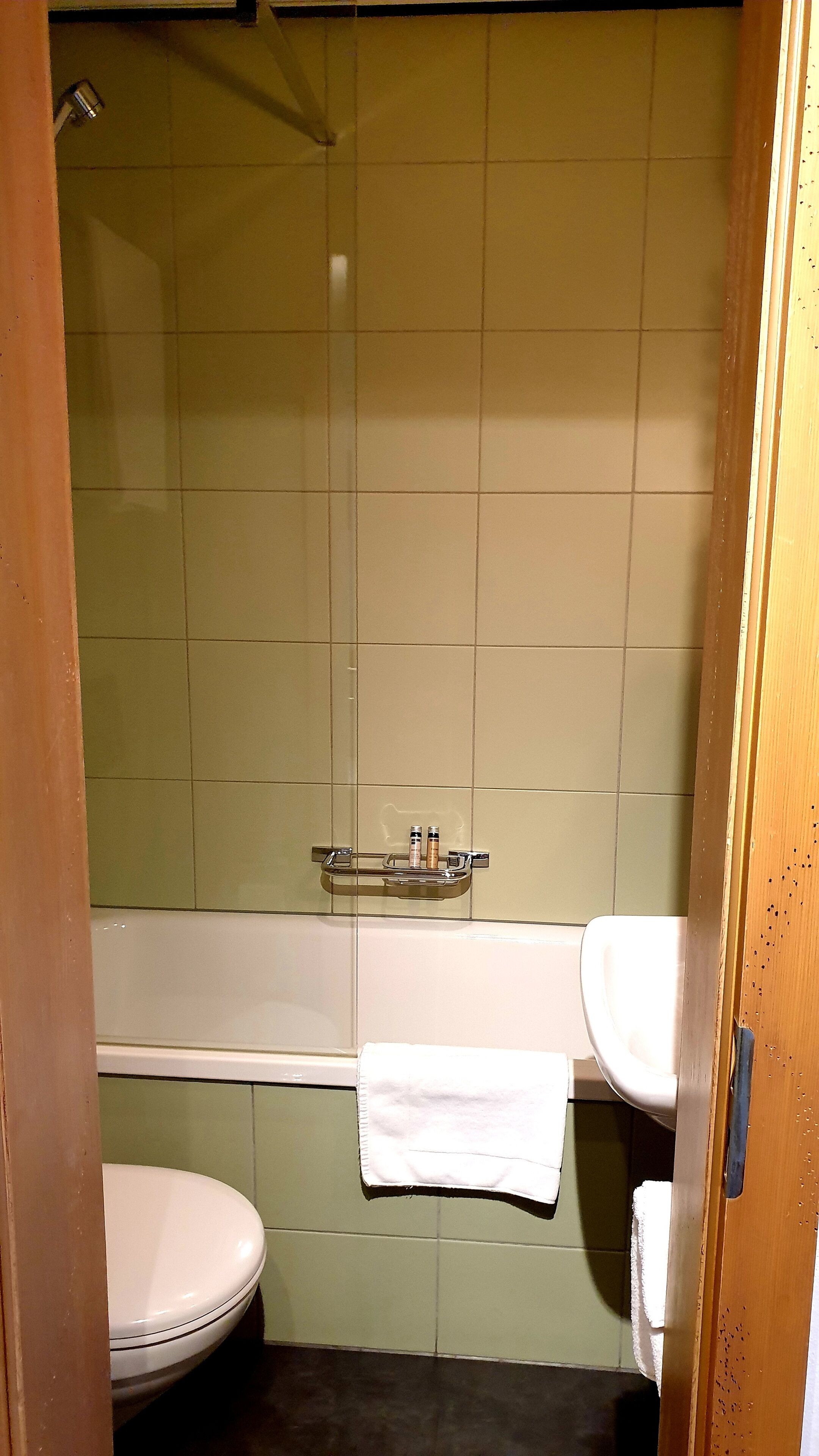 A bathroom with a white toilet, a white sink, and a bathtub.