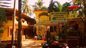 A yellow house with a sign advertising rooms for rent in Vagator Goa. - Yellow House (Vagator)