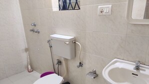 A bathroom with a toilet, bidet, and sink. - Yellow House (Vagator)