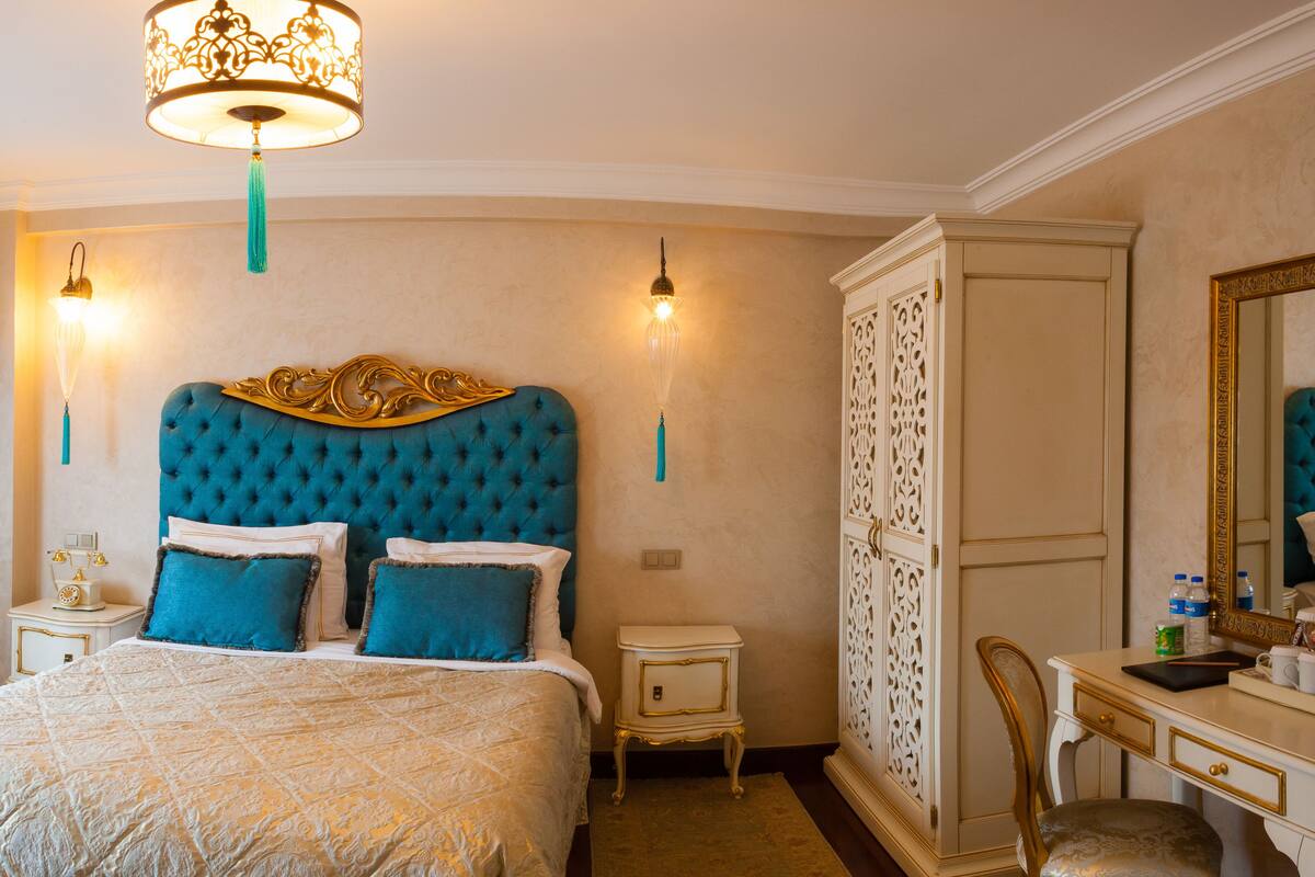 Quarto com uma cama grande, mesa de cabeceira, penteadeira e espelho.