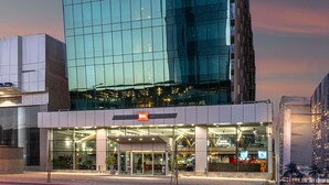 A modern hotel with a glass facade, a prominent entrance, and a visible restaurant sign. - Ibis Riyadh Hotel Al Muhammadiyah United Company Branch (Riyadh)