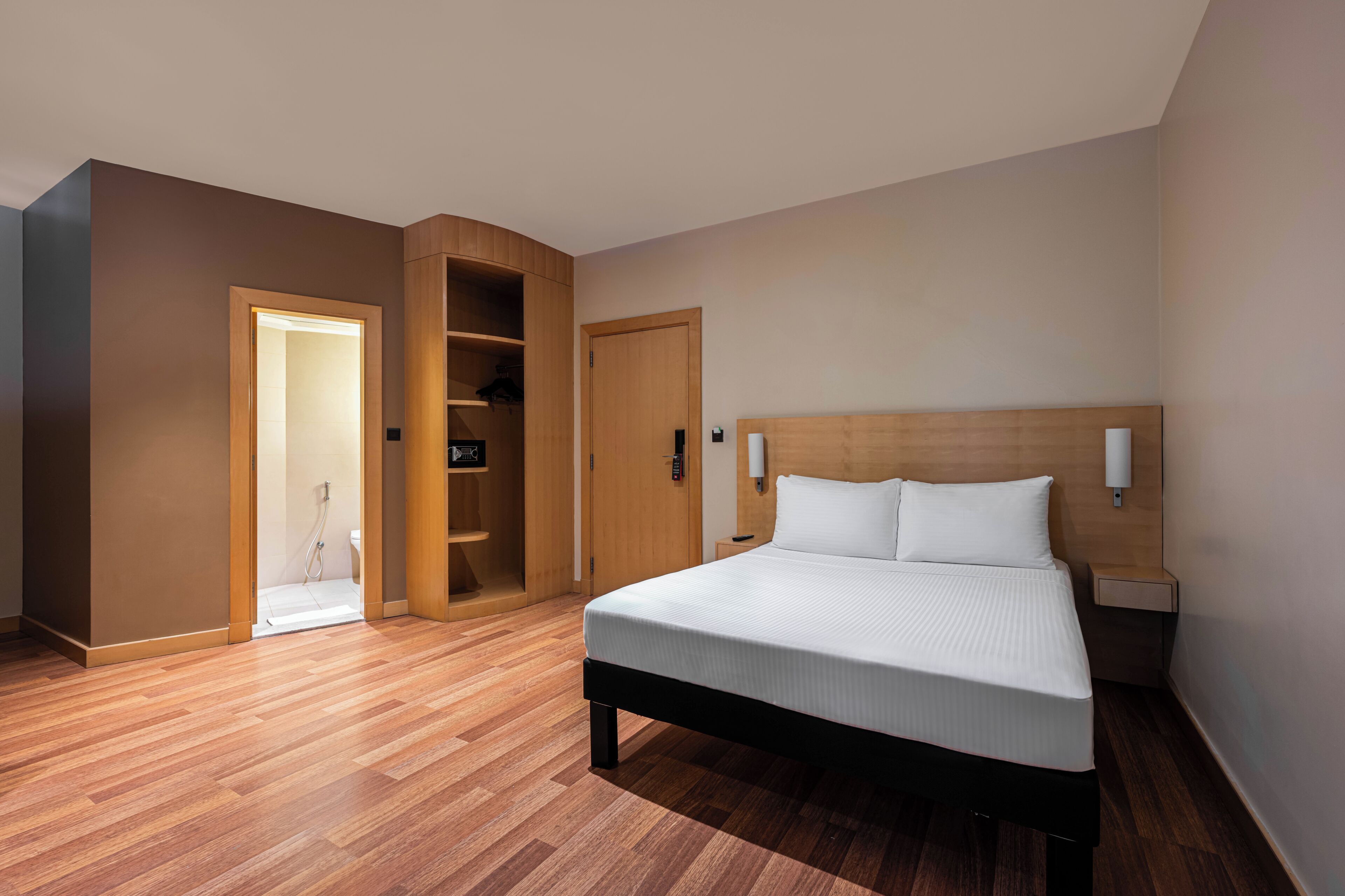 Un dormitorio con cama, armario de madera y puerta de baño.