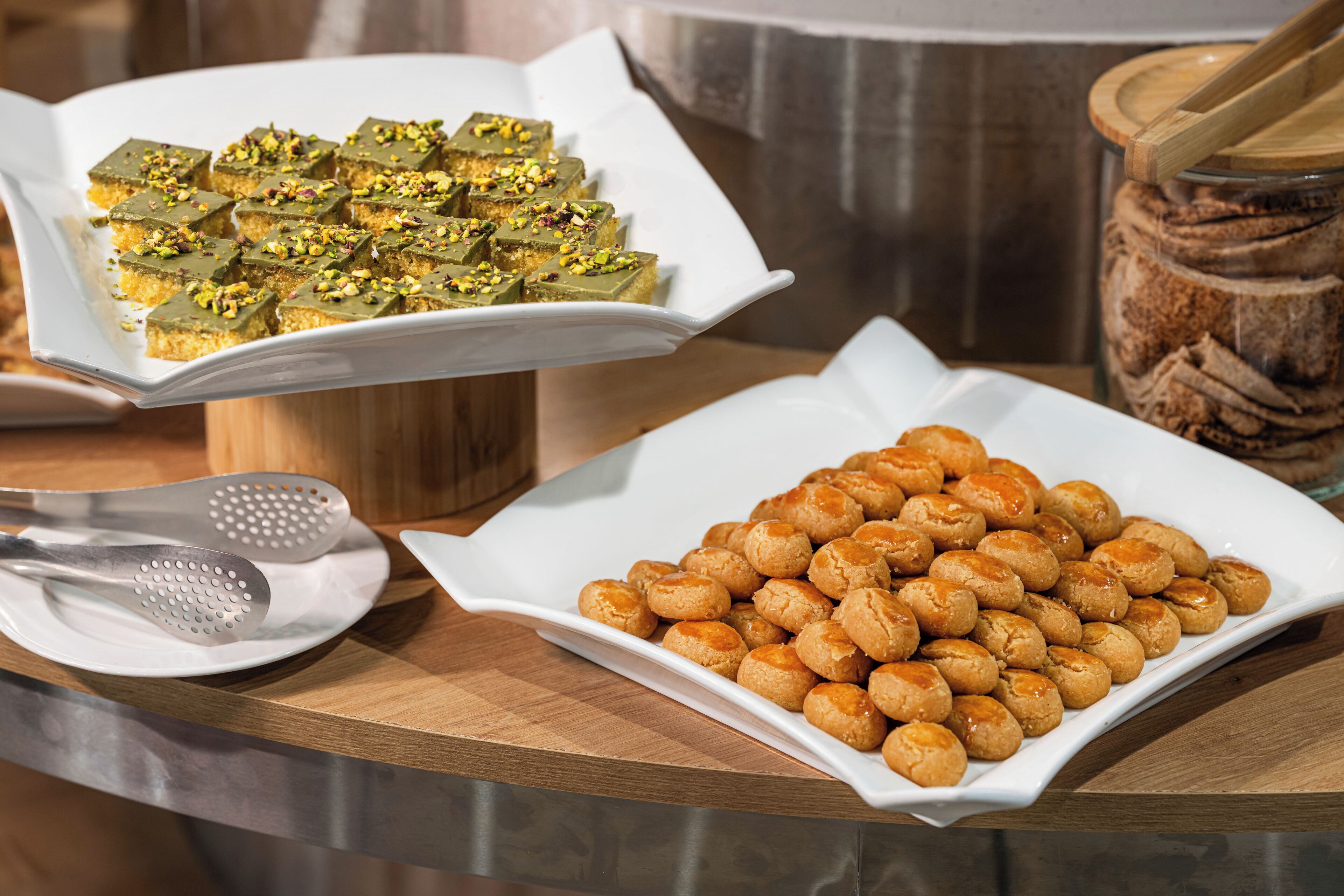 Une table avec deux plats de nourriture, une pince et un bocal.