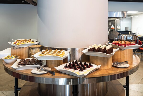 Un buffet proposant une variété de desserts et agrémenté d’un pilier central.